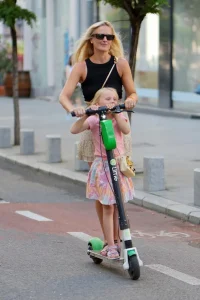 Blonde vrouw en kind op een Elektrische Step